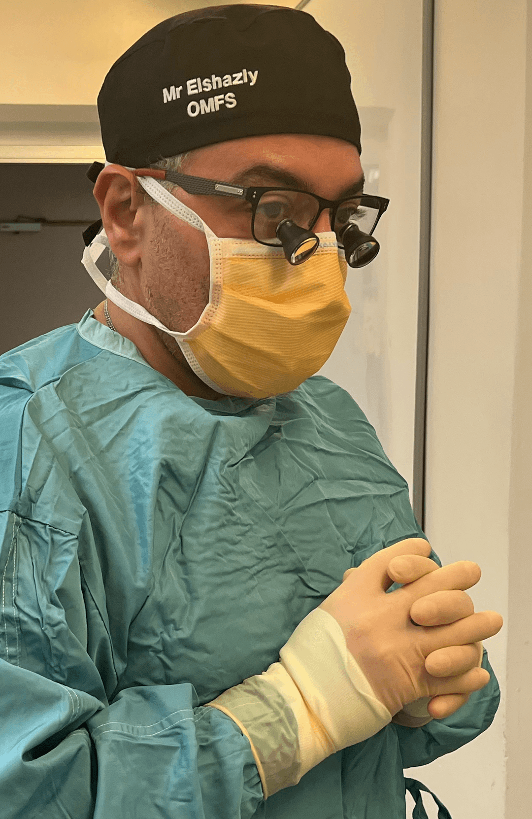 Mr Sherif Elshazly gowned, gloved and wearing surgical loupes before an operation